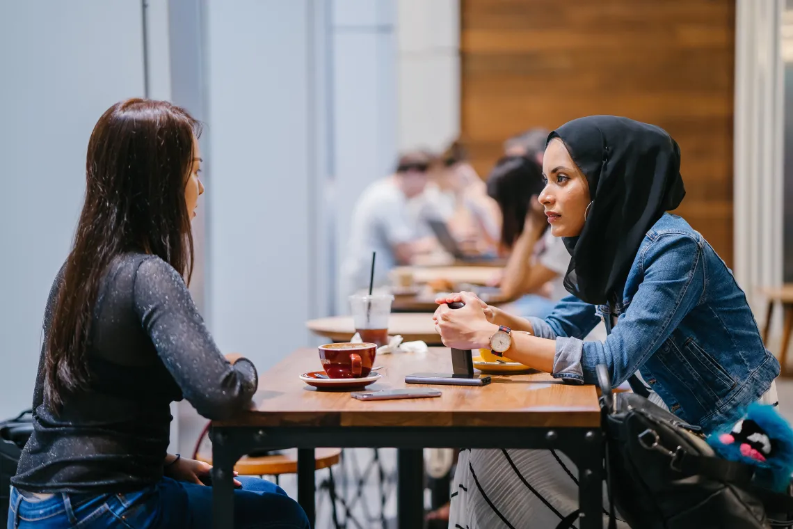 two people at a table talking